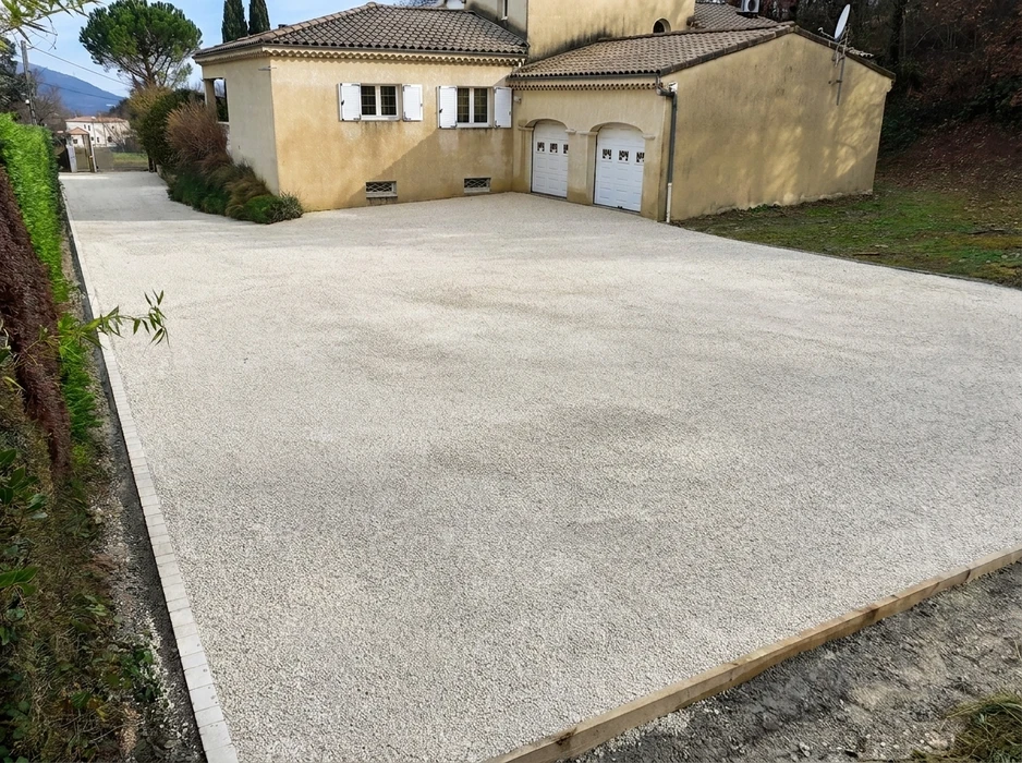 Allée de parking extérieure nouvellement aménagée devant une maison provençale en crépi beige avec double garage