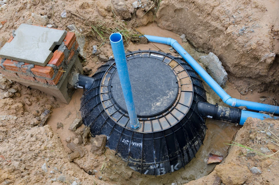 Chantier extérieur d'installation d'assainissement avec regards en béton partiellement enterrés