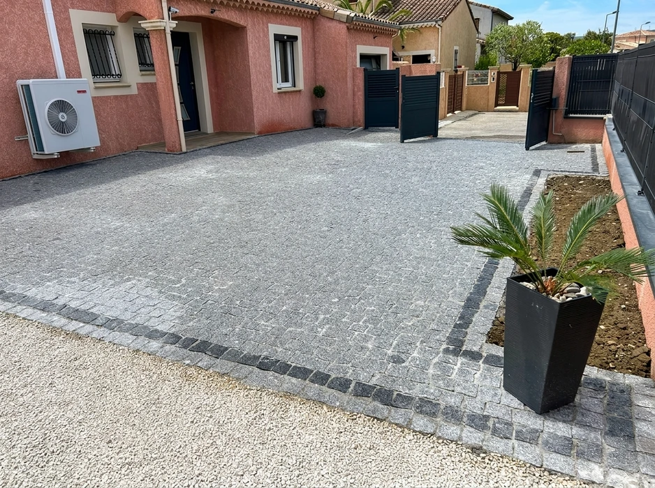 Allée d'accès privée nouvellement réalisée, en résine drainante sur grave compactée, bordée de pavés en pierre calcaire beige