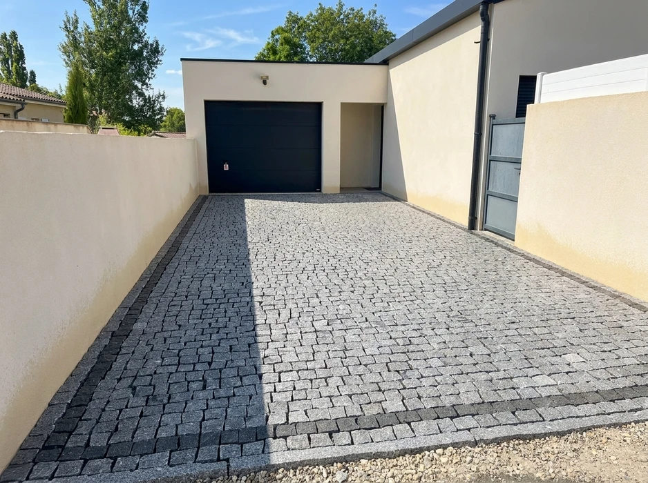 Allée de jardin privée en béton désactivé beige rosé, délimitée par un caniveau central en pierre naturelle